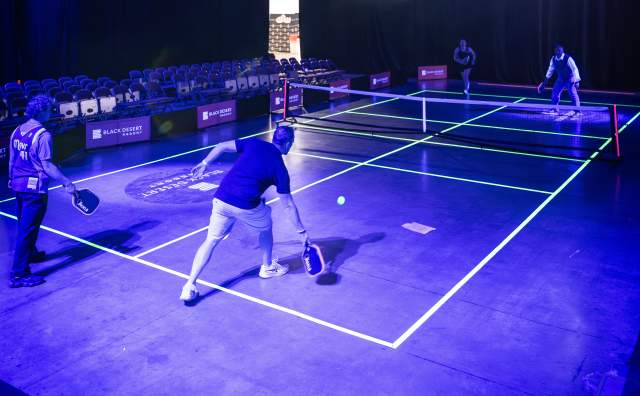 People playing pickleball in a glow in the dark court