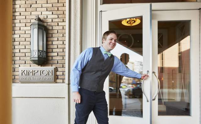 Staff opening the door to a Kimpton hotel