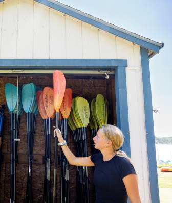 A white man and a white woman size up oars as they rent a kayak from Brittingham Boats