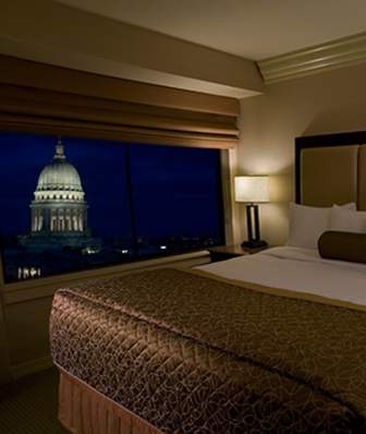 A king bed with a view of the State Capitol at the Madison Concourse Hotel and Governors Club
