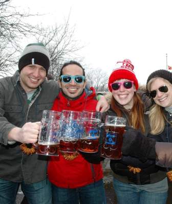 A group of five friends clinking beer steins outside at Bockfest