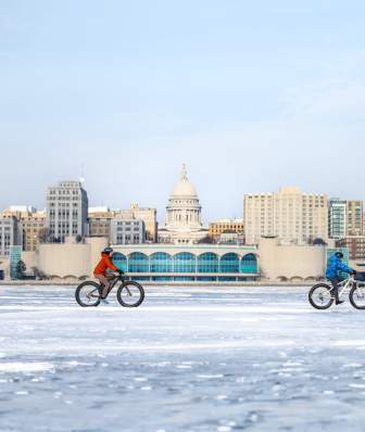 2 people bike on frozen Lake Monona