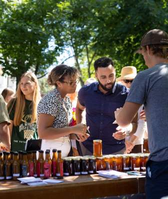 Two people sample salsa at the Dane County Farmers' Market