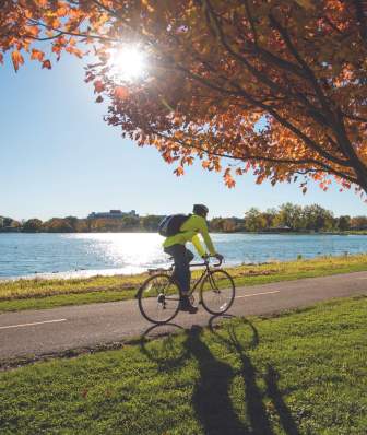 A man rides a bicycle along the shores of Lake Monona during fall