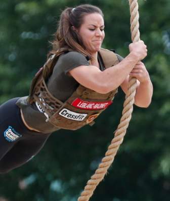 A woman swings on a rope while competing in the CrossFit Games
