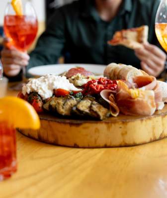 An antipasti board surrounded by Italian cocktails at Bar Corallini