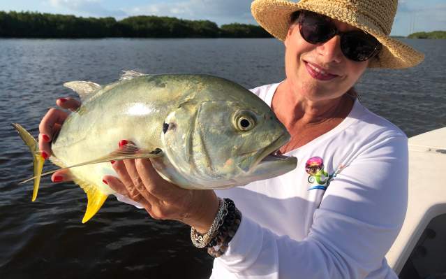 Fishing: woman holding freshly-caught Crevalle Jack