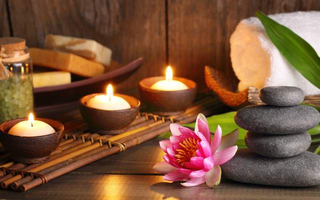 Candles, soaps, a flower, and treatment rocks at a spa