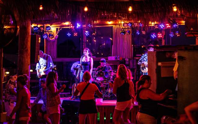 Band on stage and people dancing at SandBar Tiki & Grill
