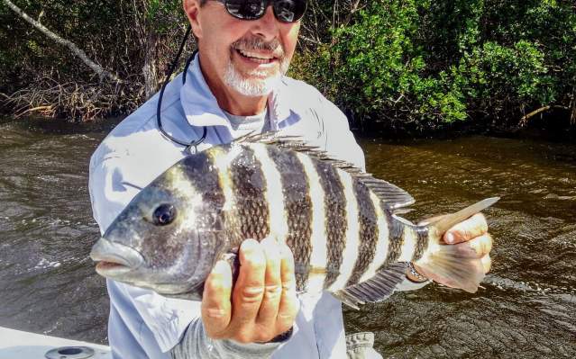 Man holding freshly-caught sheepshead fish