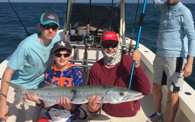 Family fishing trip, showing off a freshly-caught barracuda