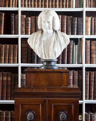 Bust on display in the Armagh Robinson Library with a row of books behind it