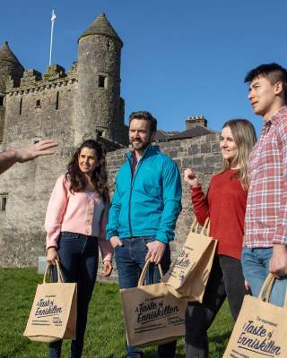 A group in the sunshine outside Enniskillen Castle enjoying an Enniskillen Taste Experience tour.