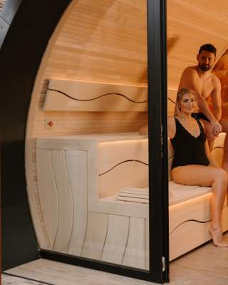 Couple sit in a sauna pod as part of a spa day experience