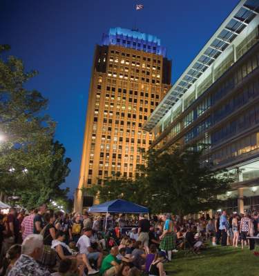 Attendees at Blues, Brews & Barbecue in downtown Allentown, with the PPL Building illuminated in the background.