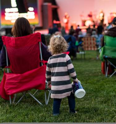 A little girl listens to a concert at Levitt Pavilion