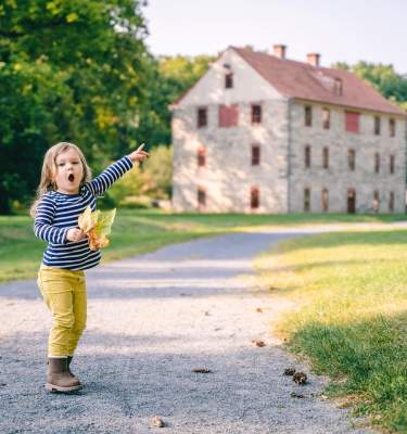 @petrasomersphoto A child holding a leaf points towards buildings of the Colonial Industrial Quarter in Historic Bethlehem, PA