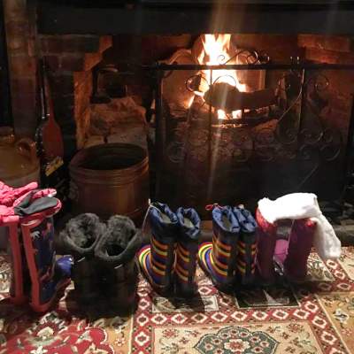 Line of wellie boots in front of fire at Waterloo Arms pub in Lyndhurst in the New Forest - Pub walks insp