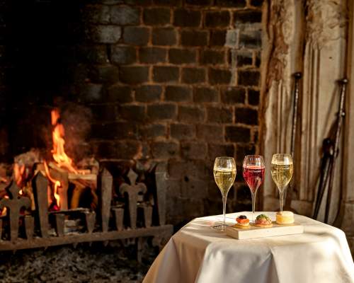A table with drinks and canapes in front of a fire at Ellenborough Park