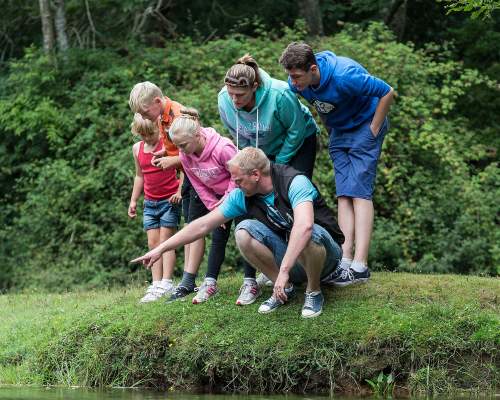 Family by water on walk in the New Forest