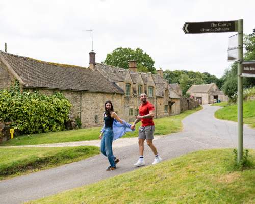 A couple holding hands walking in Notgrove