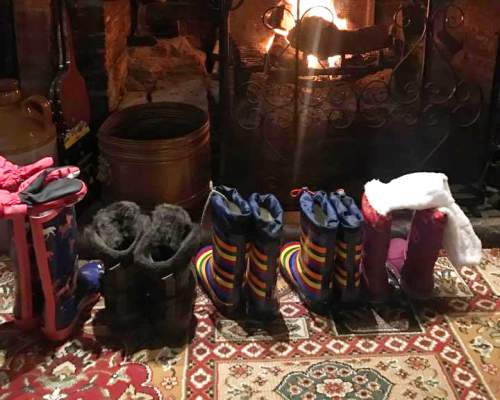 Line of wellie boots in front of fire at Waterloo Arms pub in Lyndhurst in the New Forest - Pub walks insp