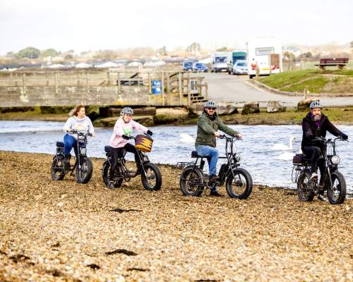 Four people riding with Jaunte Bike cycling on the beach