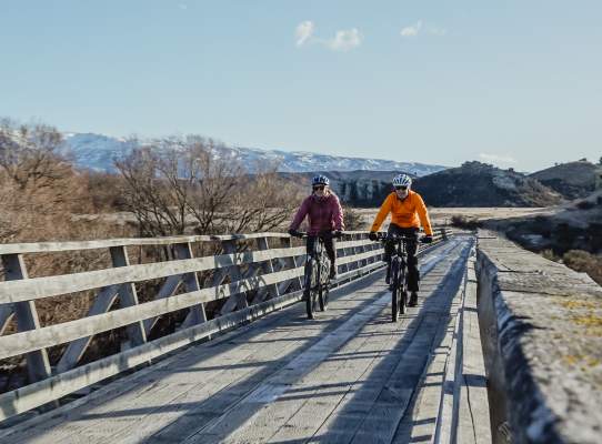 People biking over a bridge
