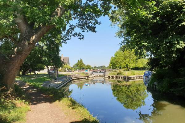 A view of St Johns Lock near Kelmscott on the river Thames. The images show the river on a bright sunny day.