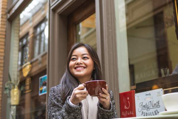 Woman sitting at table outside Comet Coffee