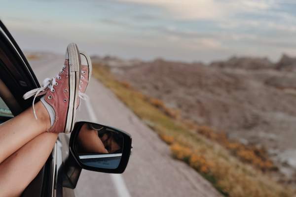 Car driving down the road with the view of Badlands National Park ahead
