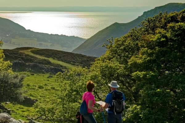 View of two walkers looking out over Sychnant Pass