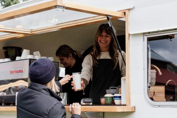 Person handing someone a coffee at the Remarkables Market