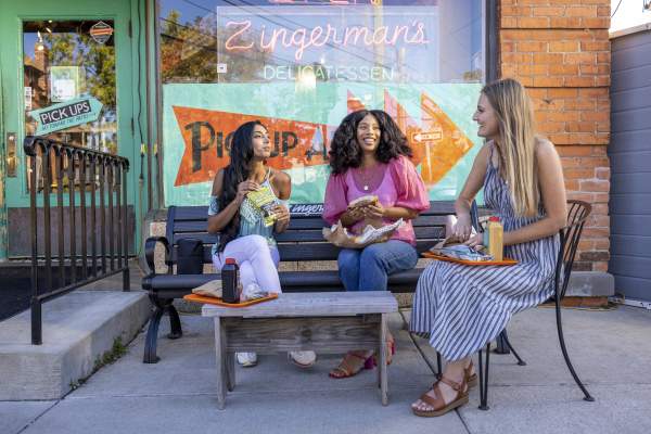 3 women eating out in front of Zingerman's Deli