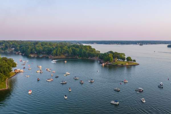 Lake with many boats on it with a piece of land seen