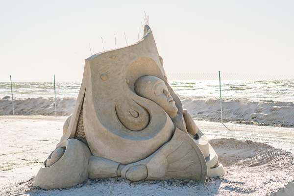 Sand sculpture depicting a face in a bionic swirling mass