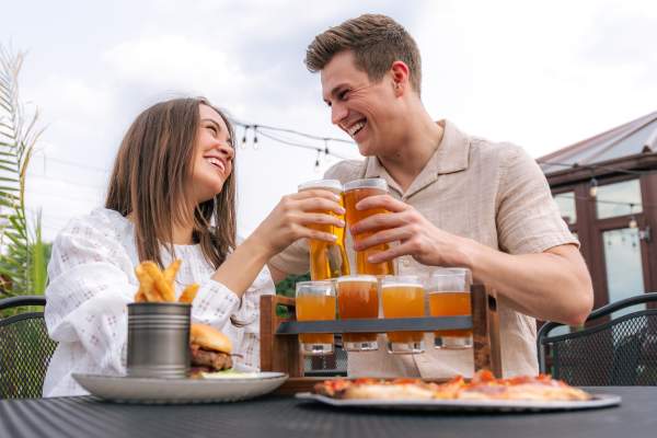 Couple doing a cheers with beer glasses at Grateful Goat.
