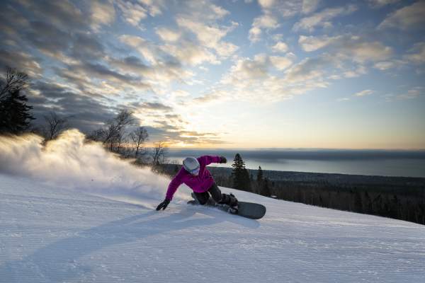 Snowboarder with Lake Superior in background at Lutsen Mountains