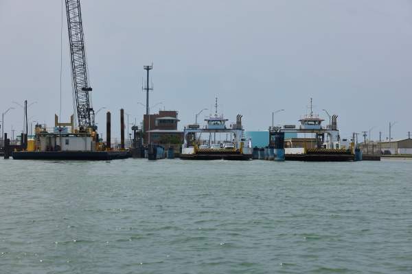 Across the water, cars are loaded on two ferry boats
