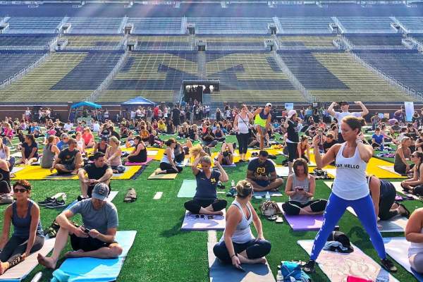 People doing yoga on the football field at Michigan Stadium