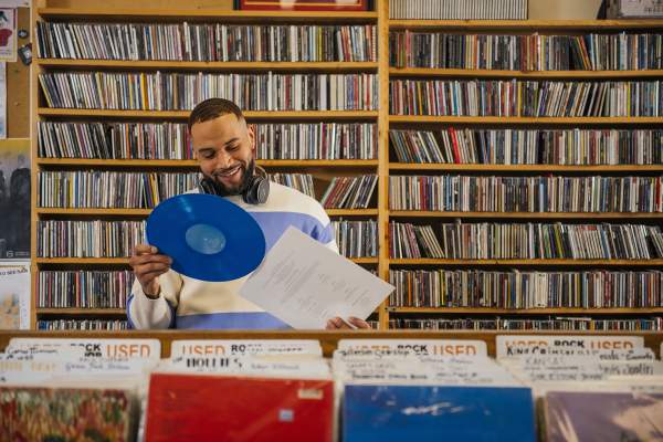 Man pulling a blue album out of record sleeve