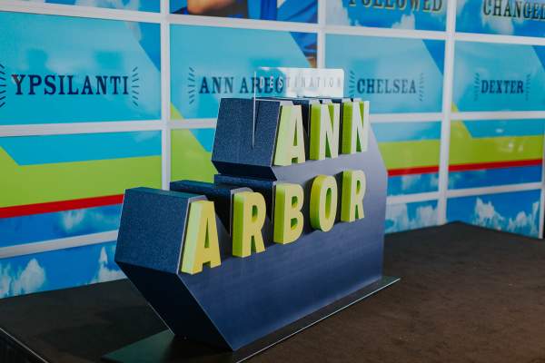Large sculpture of Destination Ann Arbor logo in green and blue