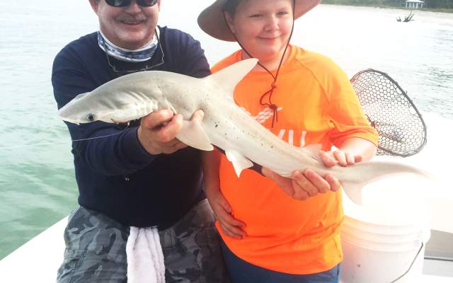 Capt. Van Hubbard and a child hold a freshly-caught shark