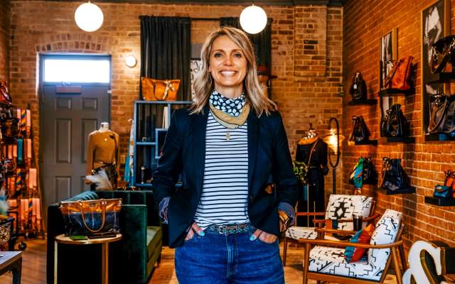 Alexis Garrett smiles in her Cheyenne studio, surrounded by handcrafted leather goods and accessories.