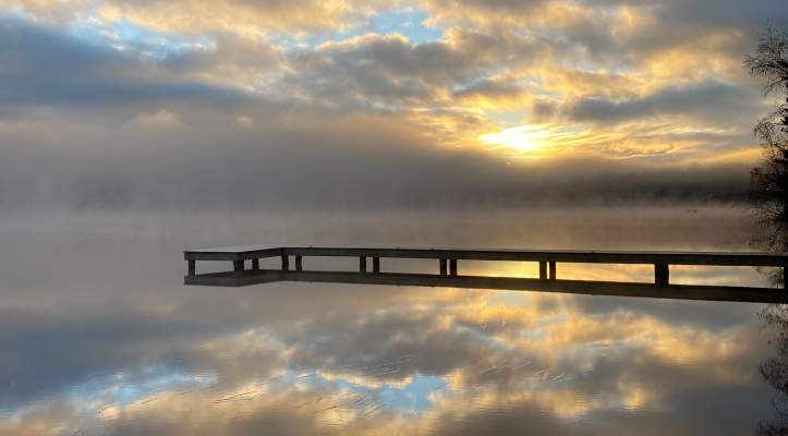Sunset and clouds reflecting on water, boardwalk