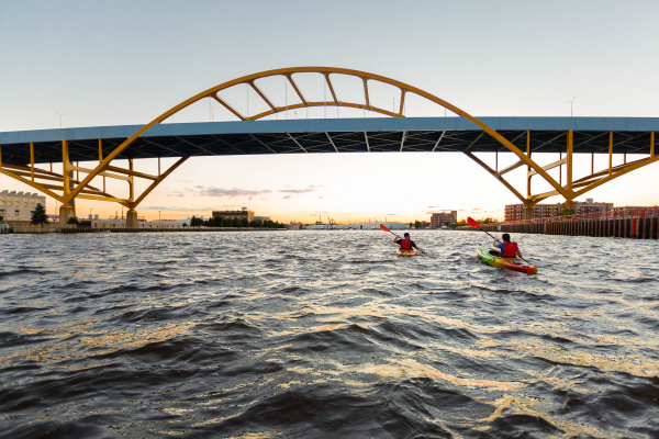 two kayakers kayaking under the Hoan Bridge