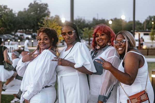 Group of Beautiful Black Women posing for the Camera in all white clothing at the White Linen Party during Juneteenth