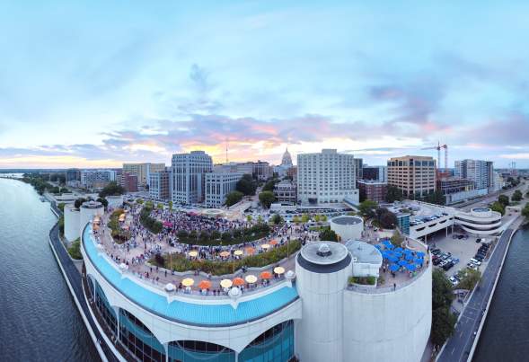 An aerial view of Monona Terrace with the Capitol far off in the background on an overcast summer evening.