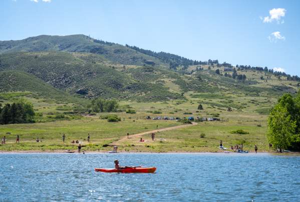 Kayaker and people recreating in background of a cove in Horsetooth Reservoir.