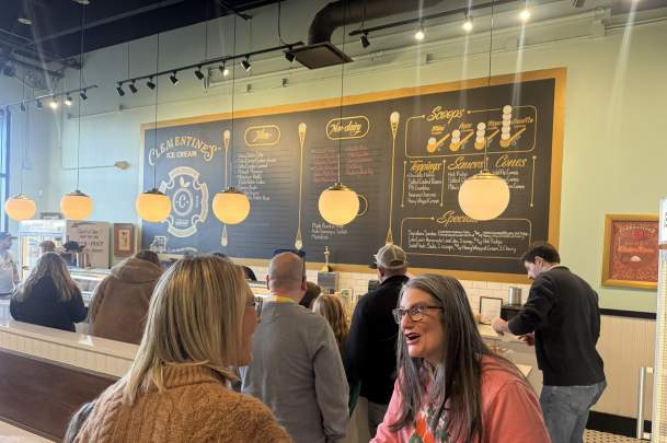 A cozy ice cream shop with guests lined up to order.